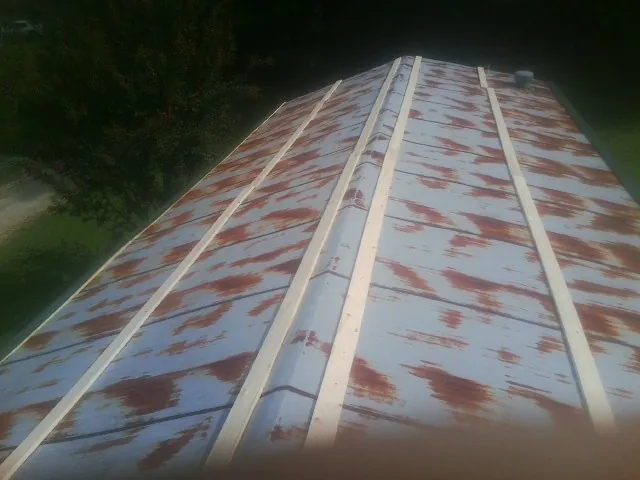 Rusted metal roof panels with new wood purlins before replacement — Storm Damage Roof Repair in Elizabethton by Roofing Brothers