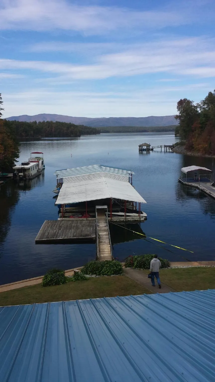 View across a lake from a newly installed blue metal roof in Elizabethton