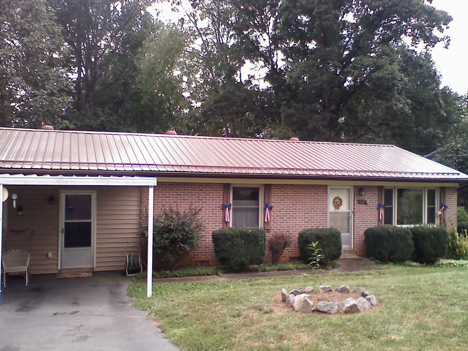 Bronze metal roof and carport on a brick ranch home — Roof Repair work by our crew in Elizabethton